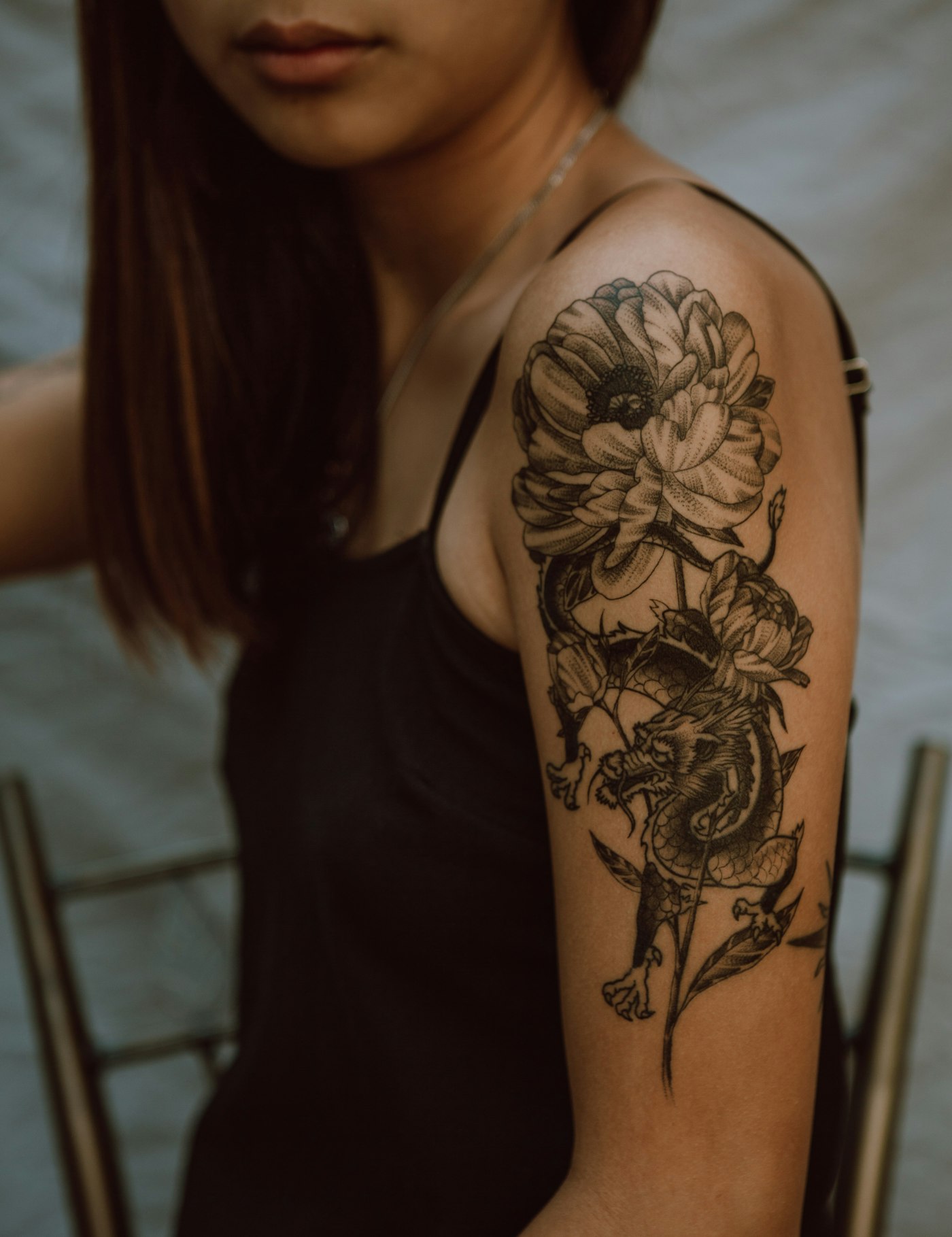 Black and grey floral tattoo on an upper arm