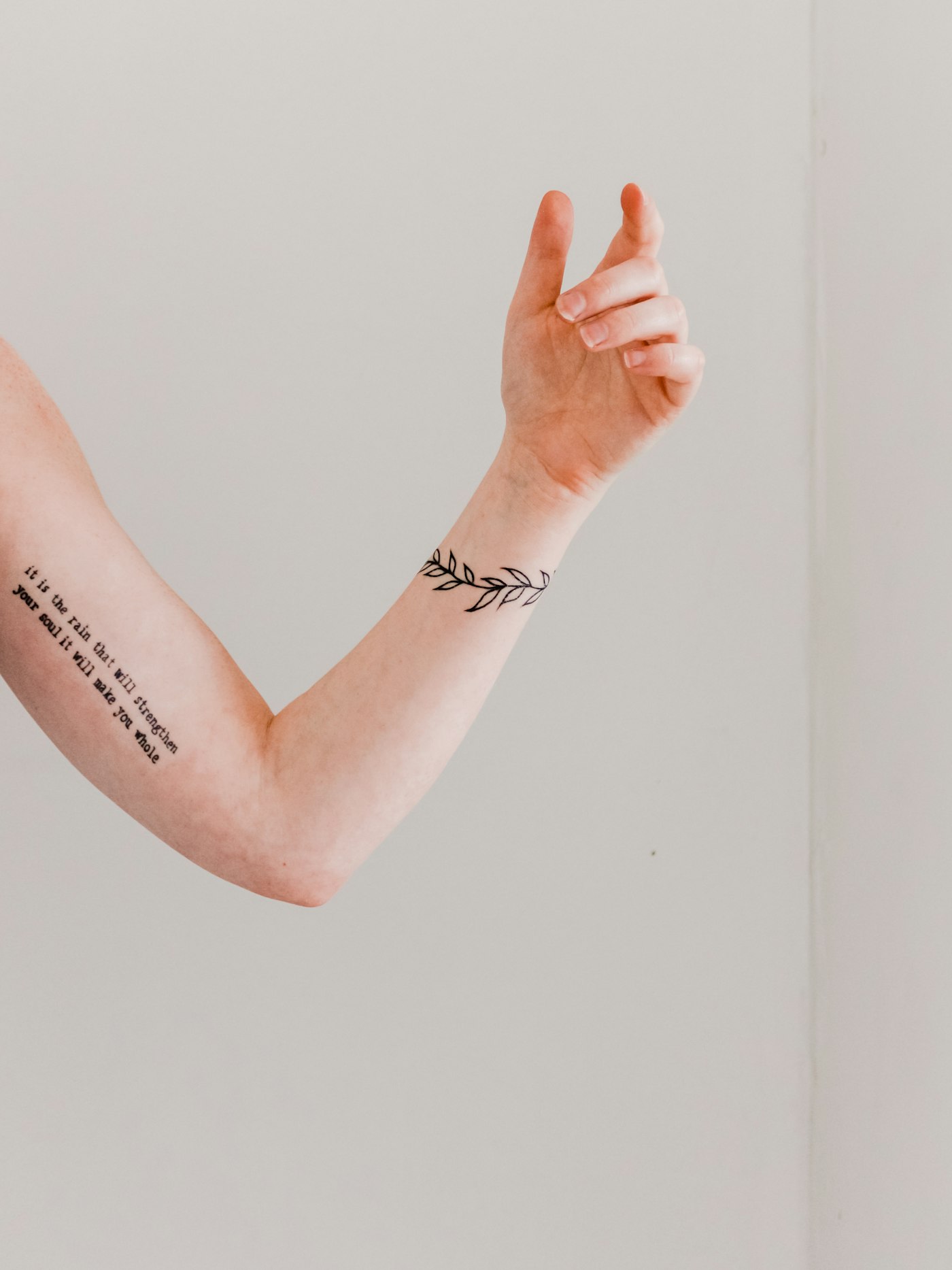 Minimal leaf band tattoo on a forearm